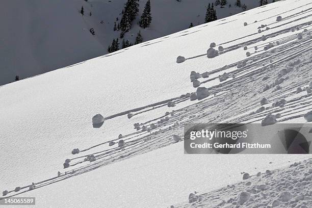small avalanches forming on the snow covered slopes - avalanche - fotografias e filmes do acervo