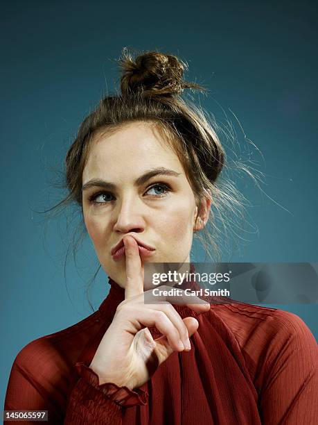 a young hip woman with her index finger on her lips, thinking - indécision photos et images de collection