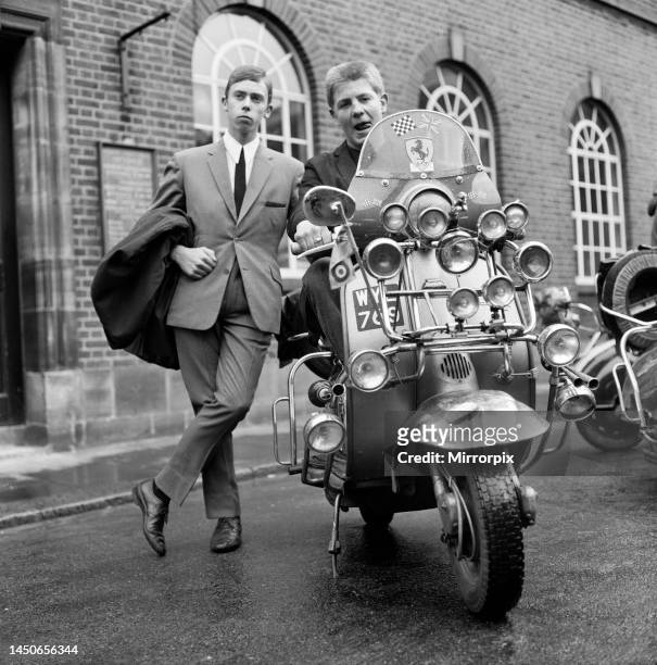 Mods wearing suits and parka's, on scooters covered with extra lights and wing mirrors. May 1964.