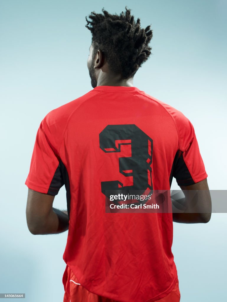 A man wearing a numbered soccer shirt