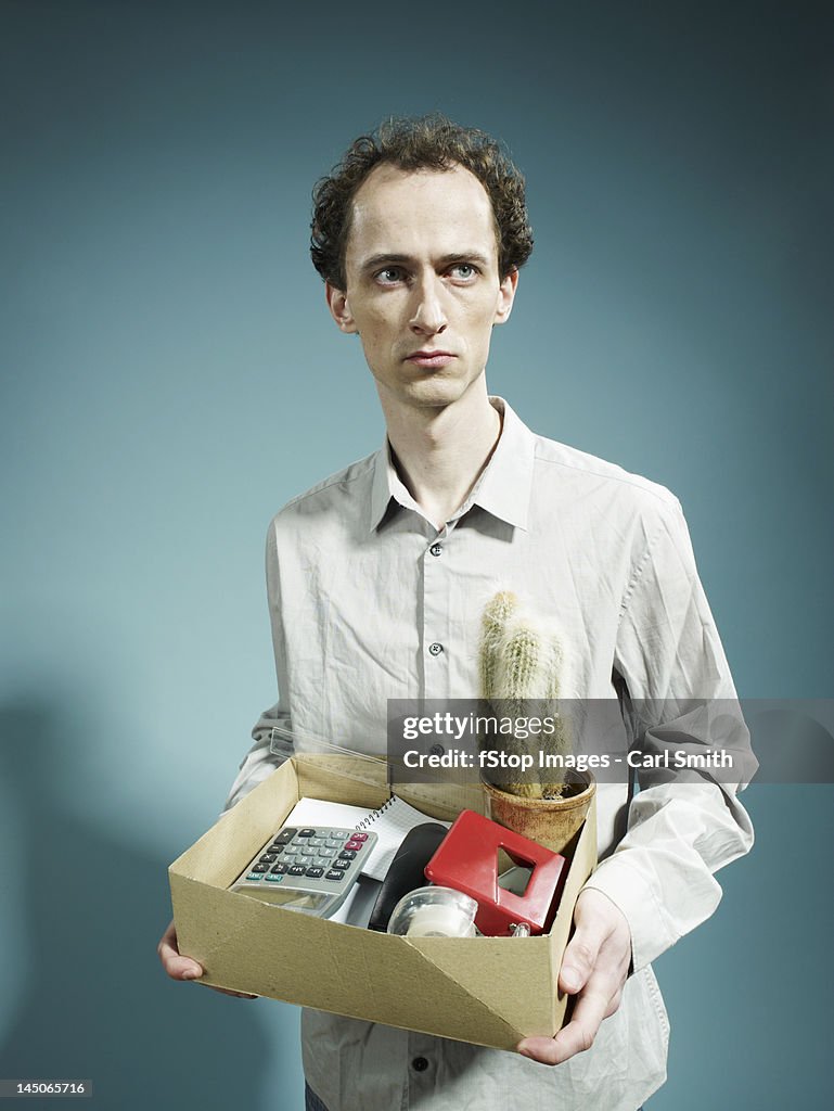 A man carrying a box of possession after being fired