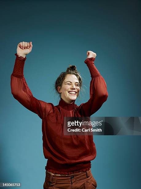 a young hip woman with her arms raised in celebration - part of a series foto e immagini stock