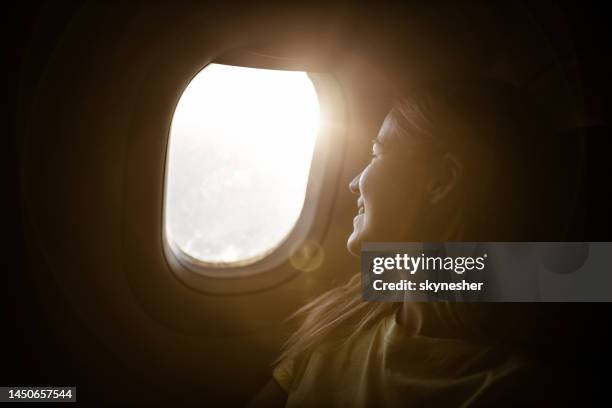 happy woman enjoying while looking through airplane window. - ekonomiklass bildbanksfoton och bilder