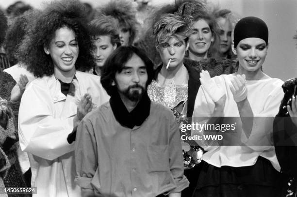 Designer Yohji Yamamoto takes a bow on the runway with model Pat Cleveland