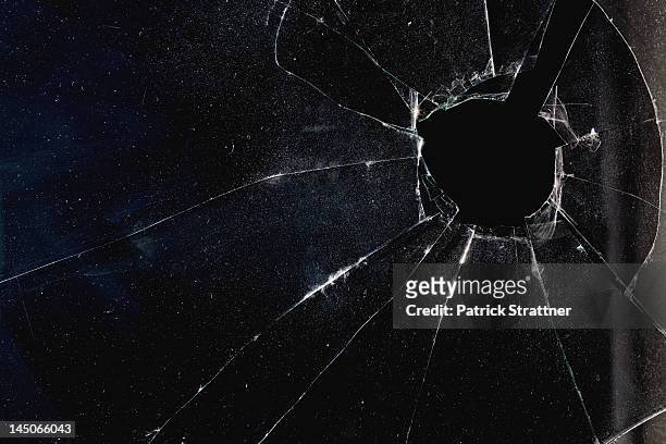 a window with a hole broken through the glass, night - 割れガラス ストックフォトと画像