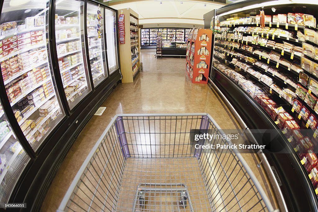 A shopping cart on an aisle in a supermarket, personal perspective