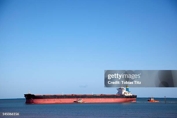 a tugboat pulling a freight ship - tug barge stock pictures, royalty-free photos & images