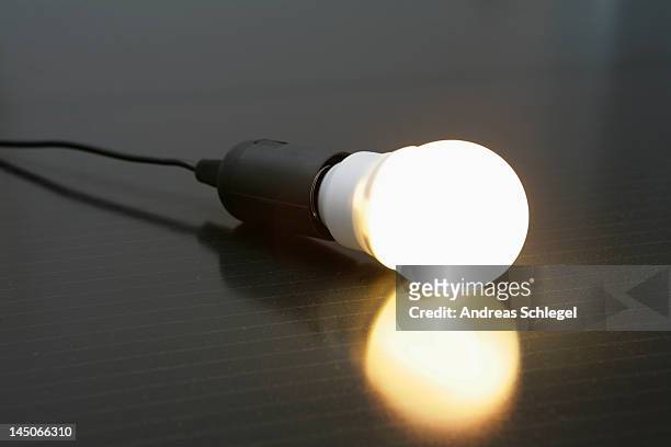 an illuminated light bulb on a solar panel - andreas solar stock pictures, royalty-free photos & images