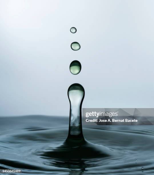 group of water droplets fall and bounce on a water surface. - regentropfen stock-fotos und bilder