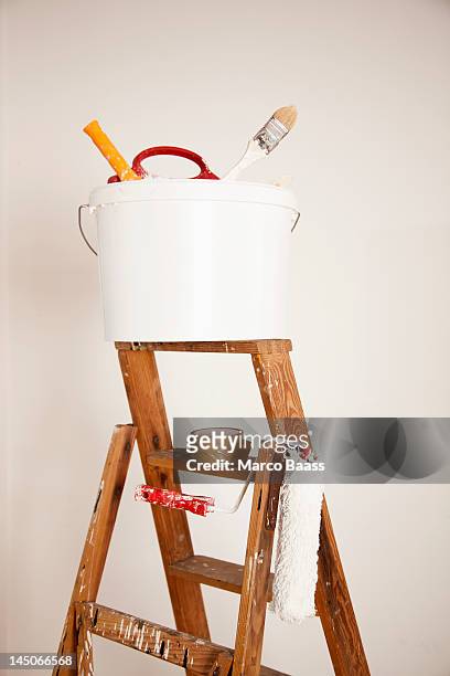 a bucket of paint supplies and paint roller on a step ladder, still life - paint tray stock pictures, royalty-free photos & images