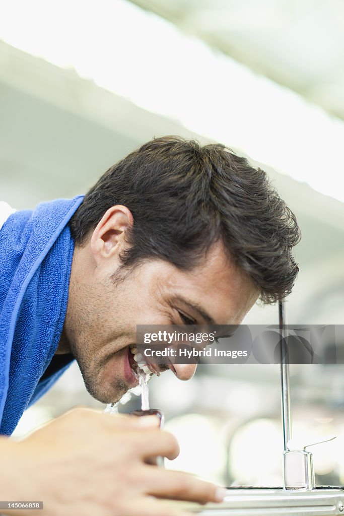 Man drinking from water fountain