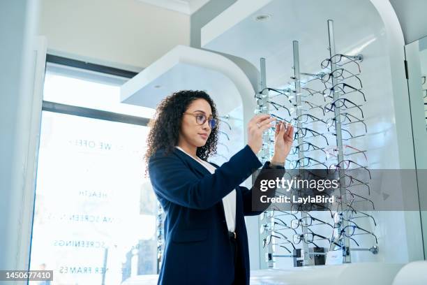 woman, optometrist store and shopping for glasses after eye test for eyesight health, blind eyes and bad vision. professional optician office, ophthalmologist shop and a customer browse eyewear shelf - choosing eyeglasses stock pictures, royalty-free photos & images