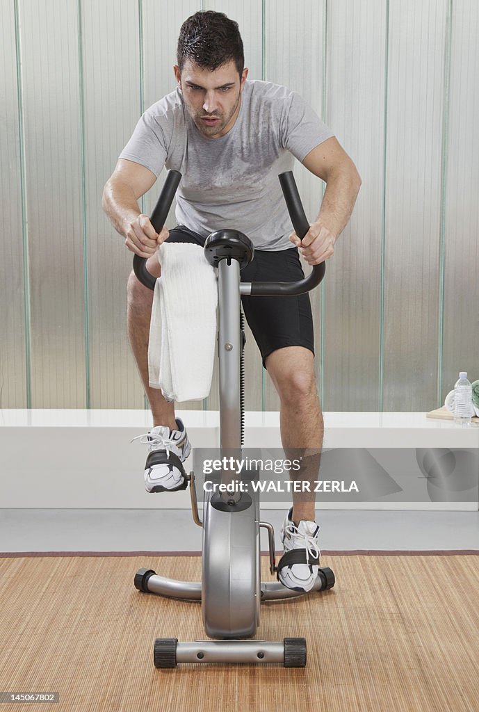 Struggling man using exercise machine