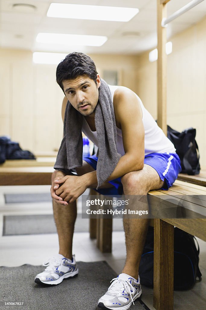 Man resting on locker room bench