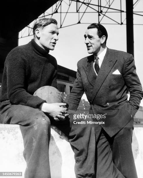 Manchester City goalkeeper Bert Trautmann talks to Frank Swift, former goalkeeper of the club, after a training session at Maine Road. Following his...