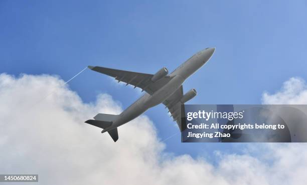 close up view of a plane flying overhead through the clouds - fuselage stock pictures, royalty-free photos & images