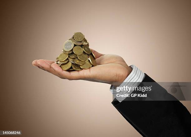 businessman holding stack of euro coins - euro in hand bildbanksfoton och bilder