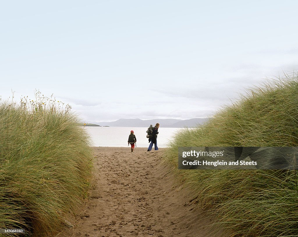 Mother and daughter walking on beach