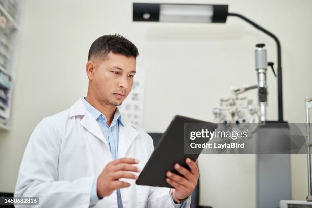 tablet, optician and vision with a man optometrist doing research in his office for an eye exam or test. healthcare, internet and optometry with a male eyecare professional at work for eyesight - profissional de oftalmologia imagens e fotografias de stock