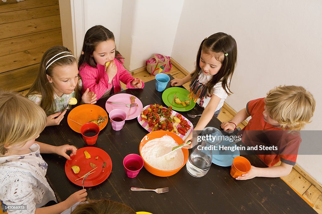 Children dipping vegetables in sauce