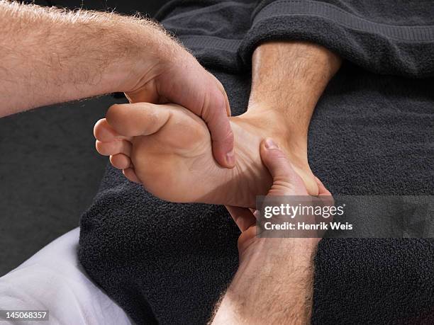 close up of man having foot massage - piede umano foto e immagini stock