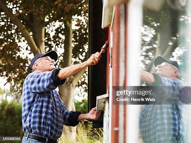 older man painting side of house - painting house exterior stock pictures, royalty-free photos & images