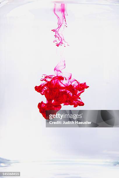 red liquid dissolving in water - dye stock pictures, royalty-free photos & images