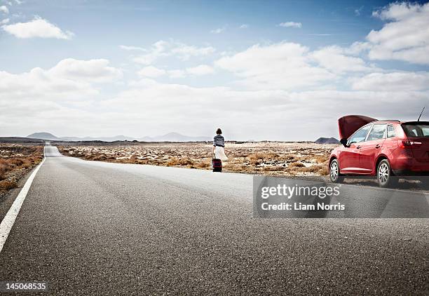 woman with broken down car on rural road - südeuropa stock-fotos und bilder