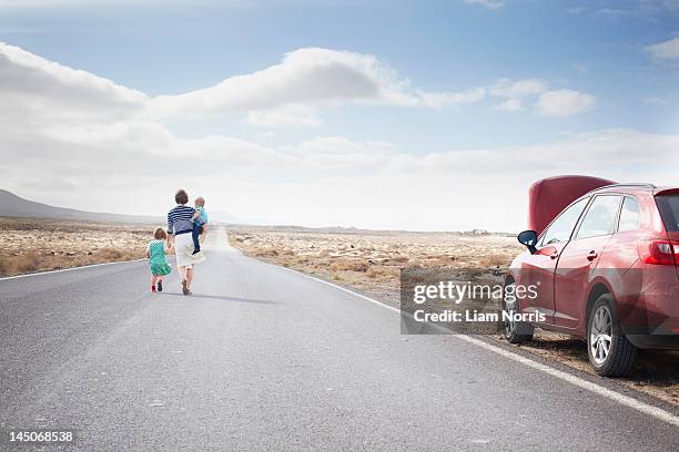family leaving broken down car on road - südeuropa stock-fotos und bilder