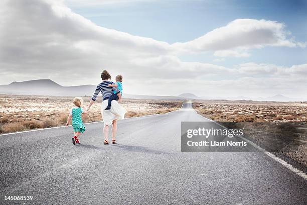 family walking on paved rural road - baby on the move stock pictures, royalty-free photos & images