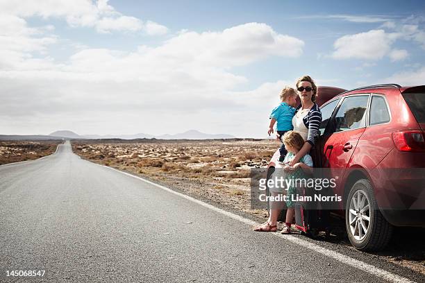 family standing by broken down car - car broken down stock-fotos und bilder