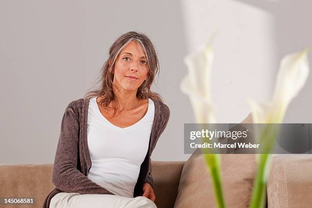 ältere frau entspannend auf sofa - bavarian man in front of house stock-fotos und bilder