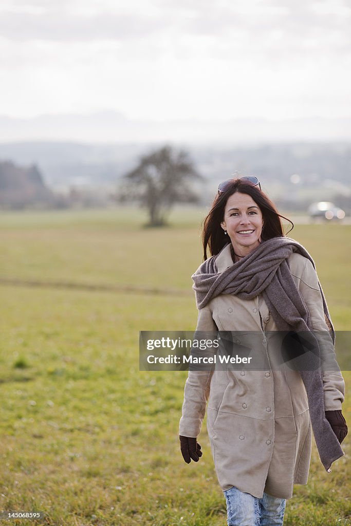 Older woman walking in rural landscape