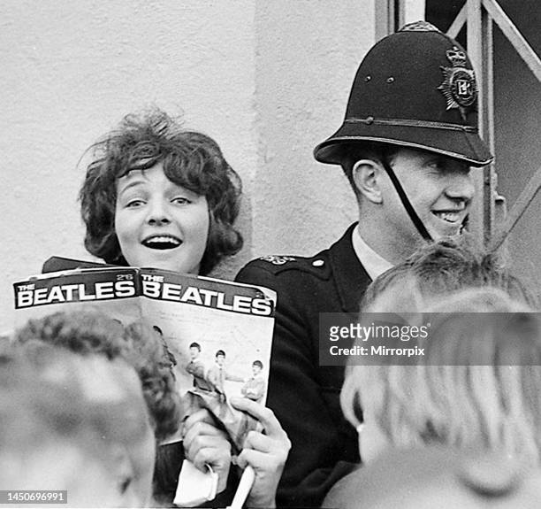 Fan holds a Beatles magazine in the crowd outside the Odeon Cinema, Cheltenham, on the first date on the Beatles' winter UK tour. 1st November 1963.