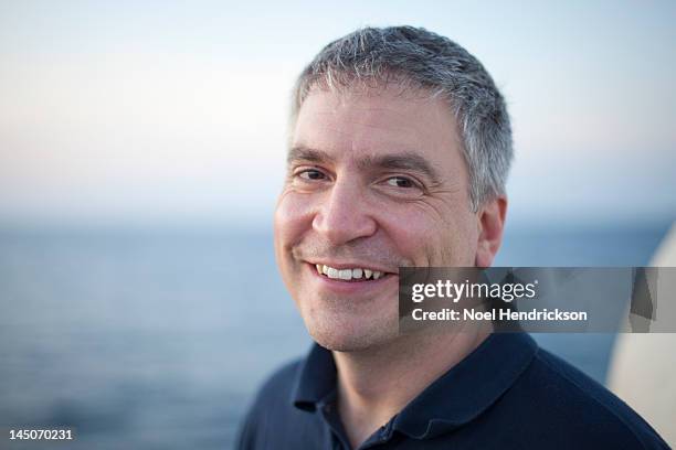 a man enjoys views of the ocean from a boat deck - navy blue polo shirt stock pictures, royalty-free photos & images