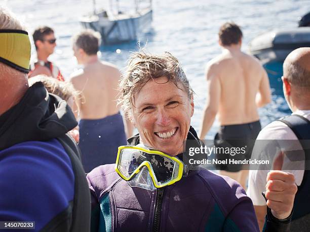 a scuba diver smiles right after her ocean dive - old people diving stock pictures, royalty-free photos & images