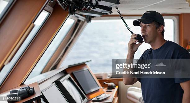 the captain uses a radio from the bridge of a boat - ships bridge 個照片及圖片檔