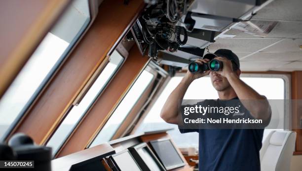 the captain of a boat looks out from the bridge - ship's bridge foto e immagini stock