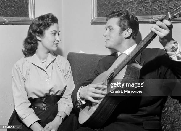 This courting couple break with tradition and exchange earrings to mark their engagement. As well as seranading his beloved with his guitarcirca 1955.