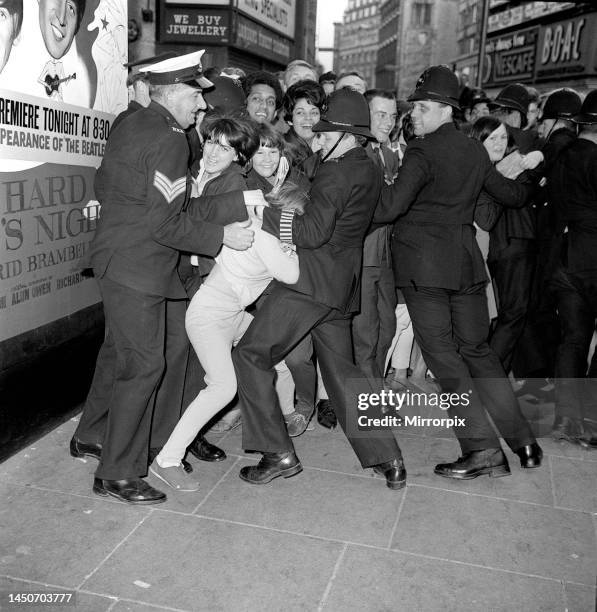 Film Premiere of A Hard Day's Night, at the London Pavilion. Police and a sailor holding back crowds of fans, who are waiting to see The Beatles. 7th...