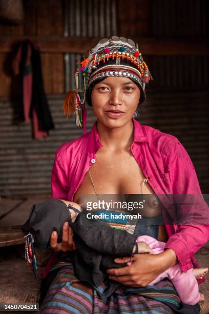 young woman from akha hill tribe breastfeeding her baby - dia bildbanksfoton och bilder