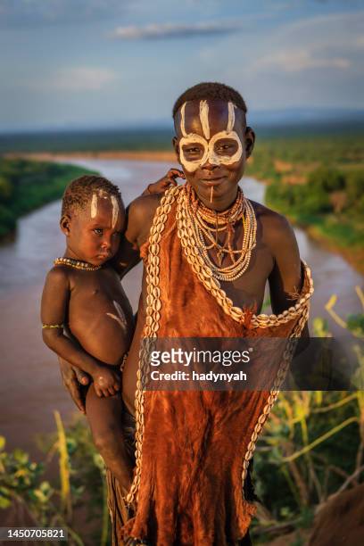 woman from karo tribe holding her baby, ethiopia, africa - african tribal face painting 個照片及圖片檔