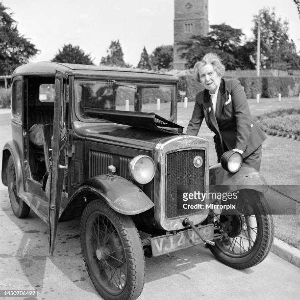 Mrs Goul looks under the bonnet of her Austin car following a breakdown on the village green, circa 1957.