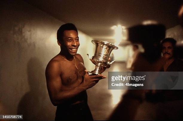 Brazilian footballer Pelé of New York Cosmos poses with a trophy in 1977.