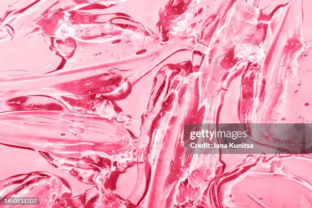 transparent pink viva magenta moisture serum for face smudged. hydrating hyaluronic acid. antibacterial gel with bubbles. cosmetic products for makeup and skin care. cosmetology. - brillant à lèvres photos et images de collection