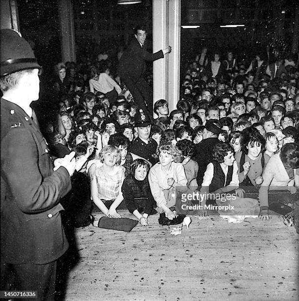 Policeman keeps watch on the rowdy audience during the Beatles' last British ballroom appearance at the Pavilion in Buxton. The show was constantly...