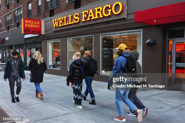 People walk past a Wells Fargo bank on Broadway on December 20, 2022 in New York City. Wells Fargo has agreed to pay $3.7 billion to settle charges...