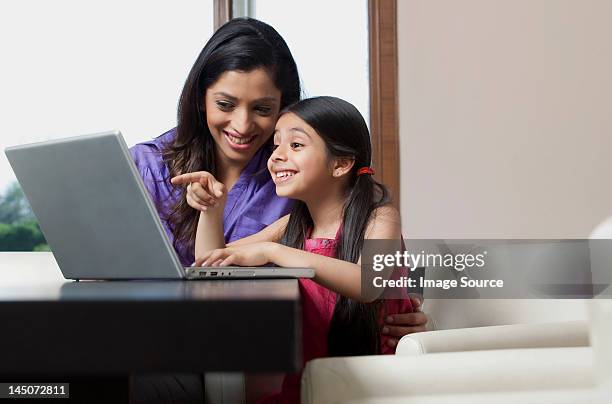 mother and daughter having fun on a laptop - indian society and daily life imagens e fotografias de stock