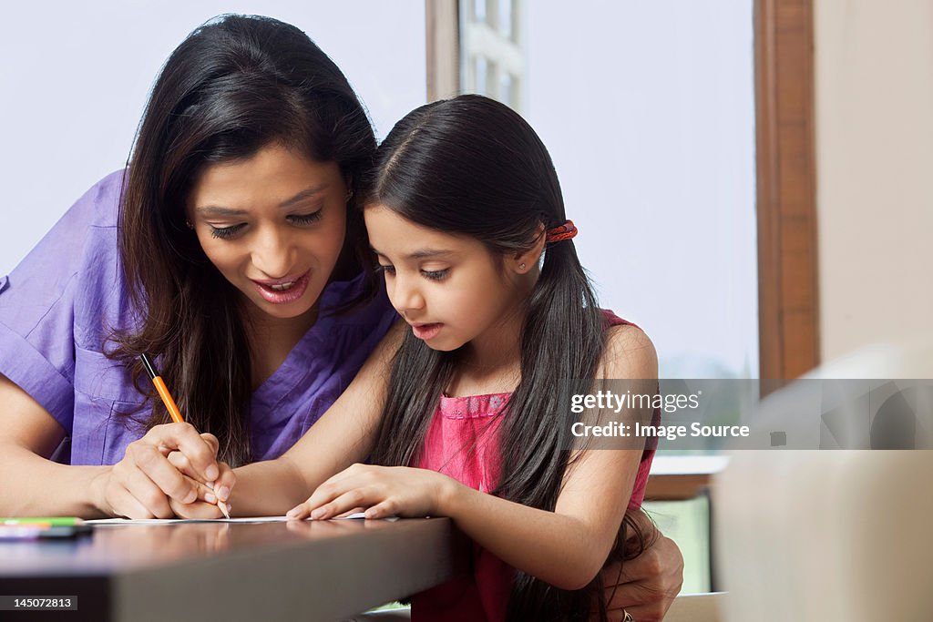Mother teaching her daughter to write