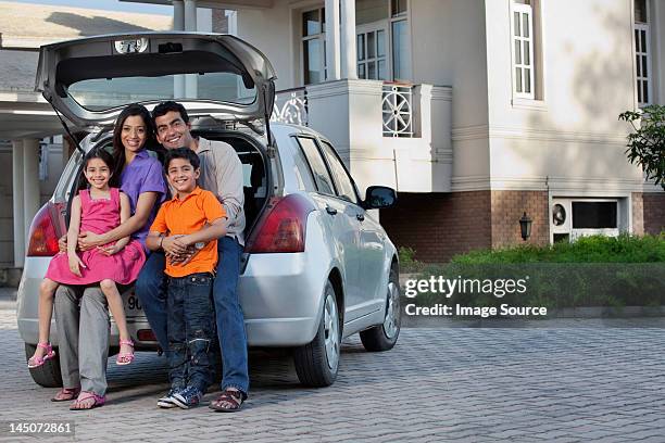 family sitting at the back of a car - family car at home stock-fotos und bilder